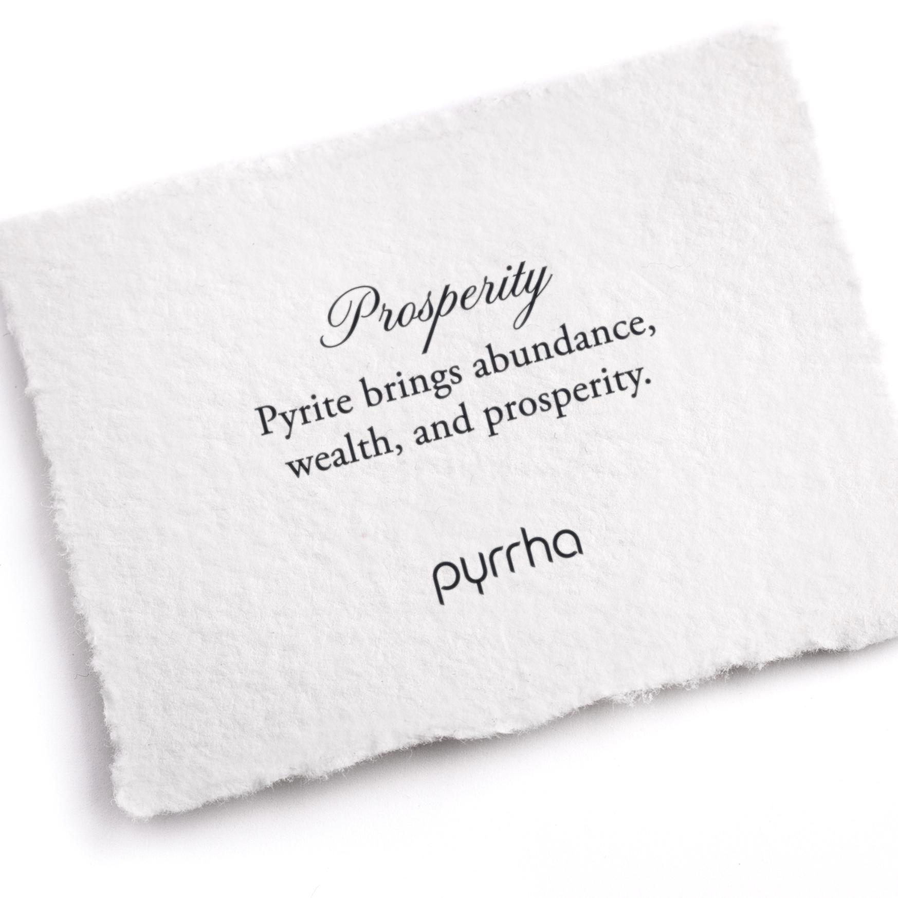 A hand-torn, letterpress printed card describing the meaning for Pyrrha's Prosperity Attraction Charm