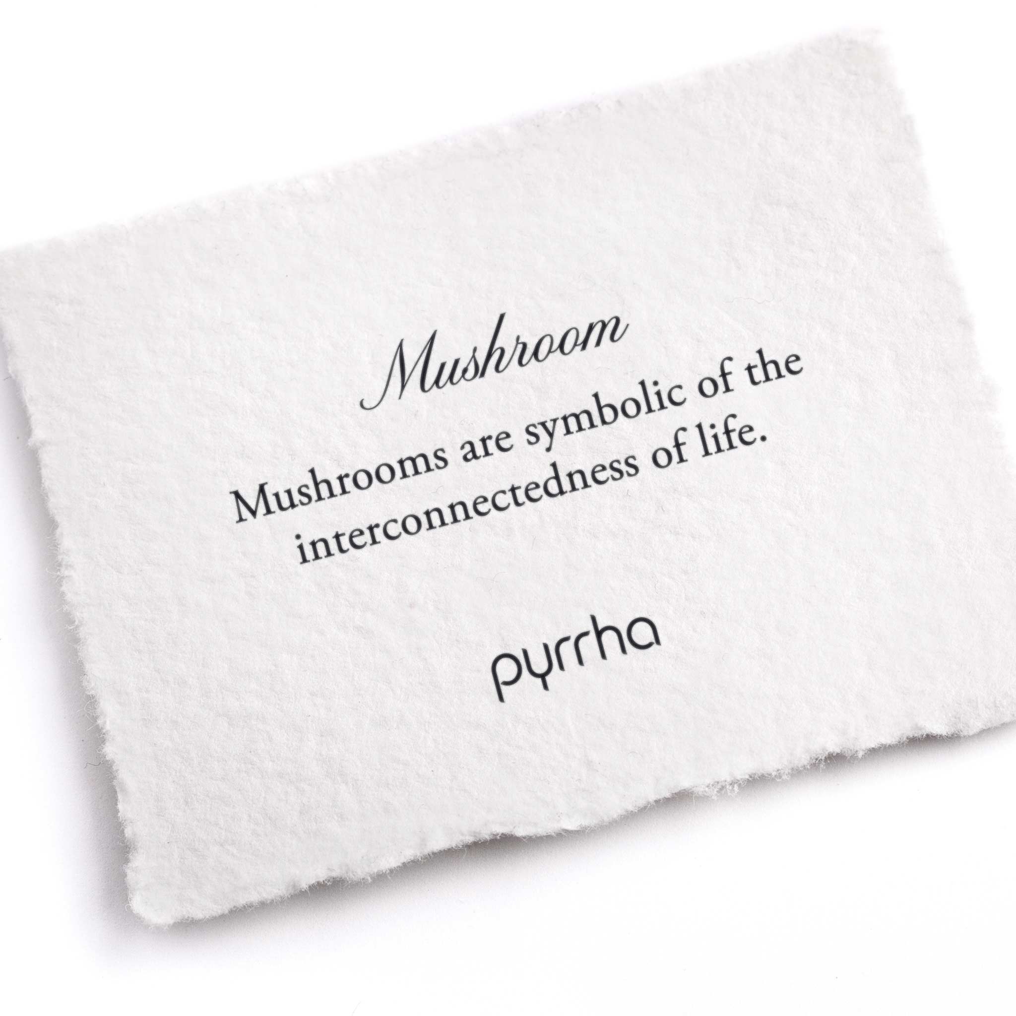 A hand-torn, letterpress printed card describing the meaning for Pyrrha's Mushroom Symbol Charm