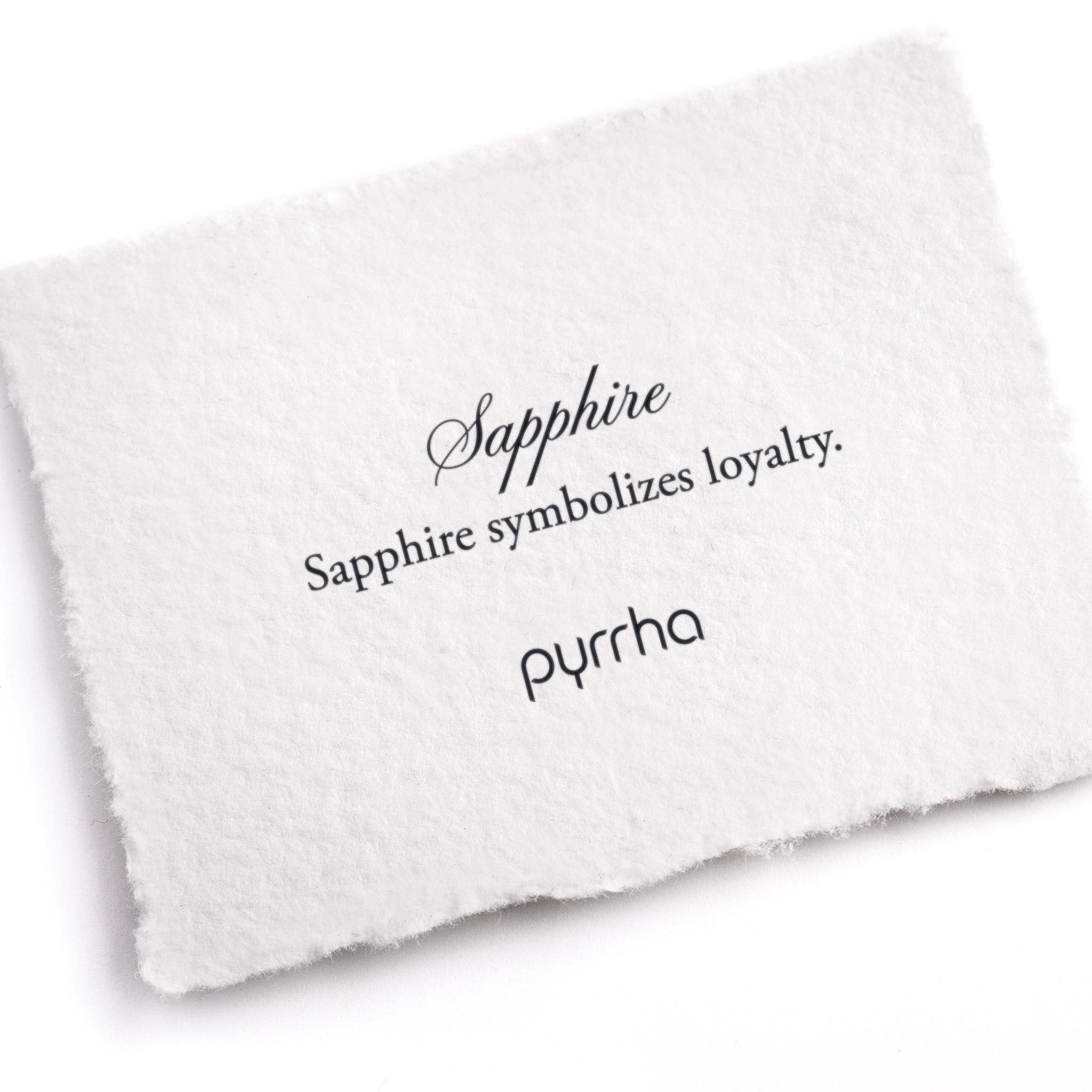 A hand-torn, letterpress printed card describing the meaning for Pyrrha's Sapphire stone