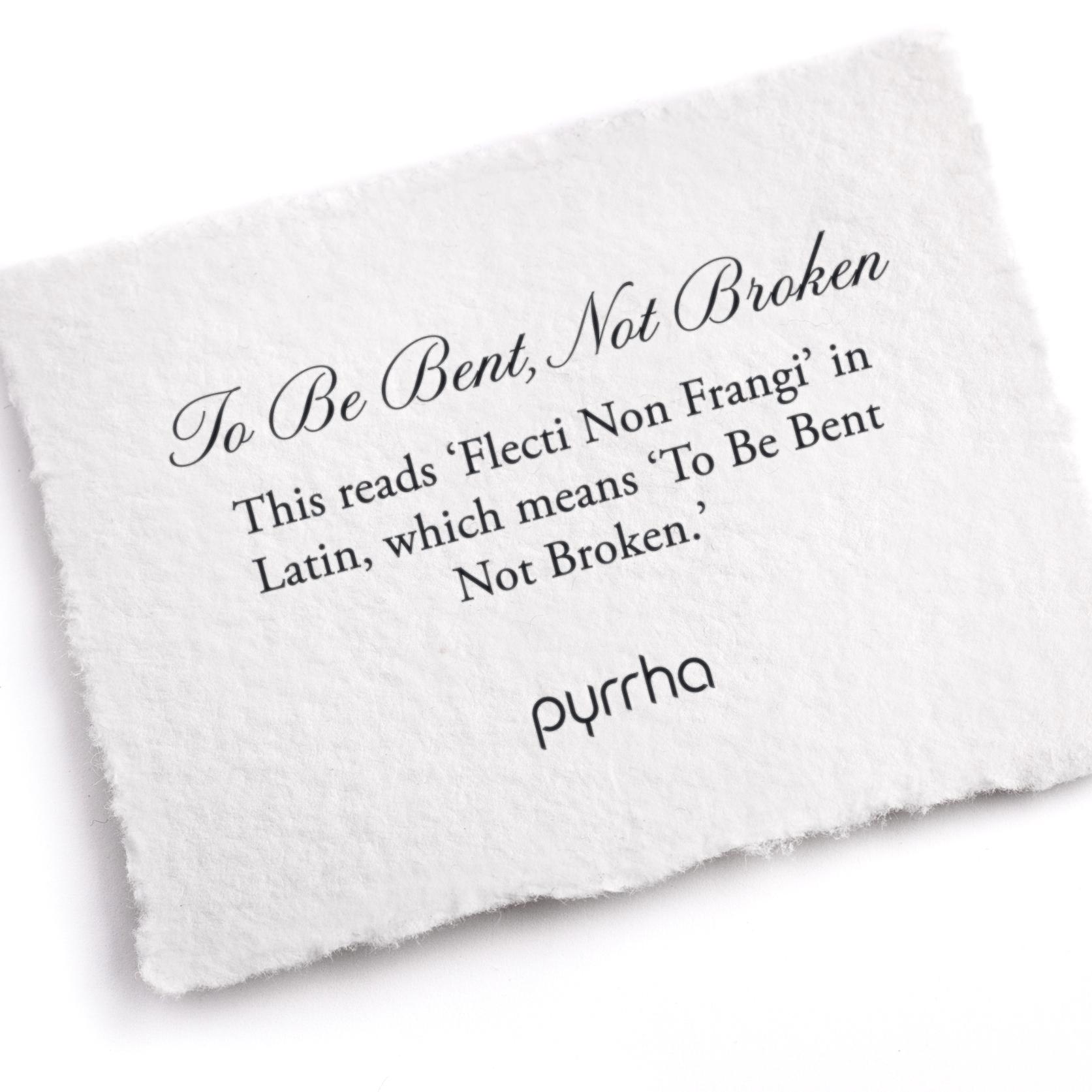 A hand-torn, letterpress printed card describing the meaning for Pyrrha's To Be Bent, Not Broken Ring