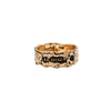 A wide 14k gold ring set with a black diamond featuring the words From Here On printed on the band.