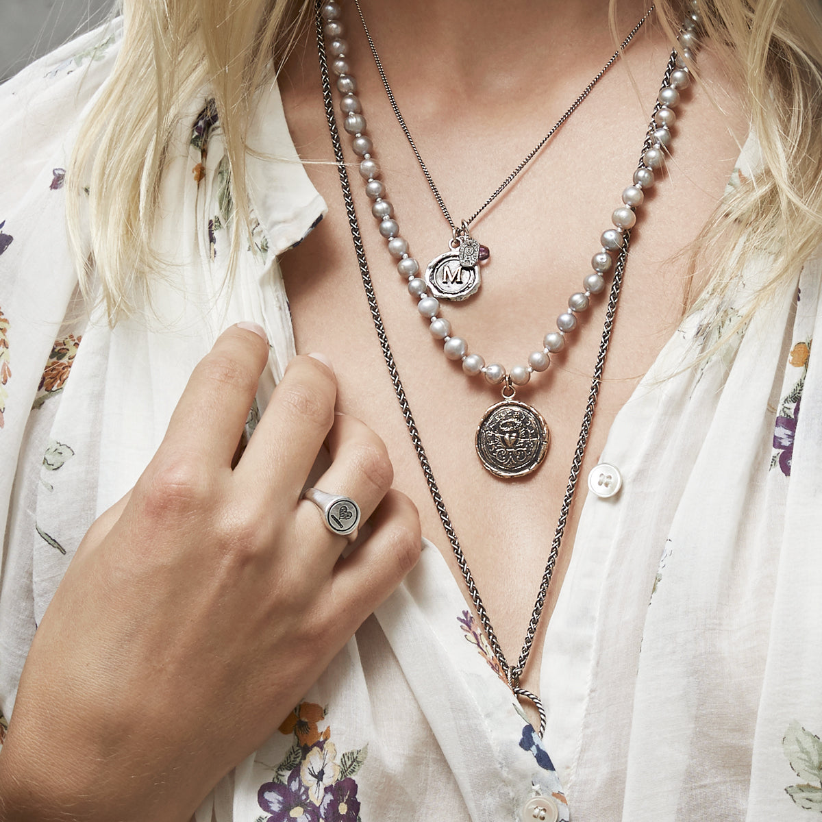 A close up of a model wearing our Heart Oval Signet Ring.