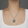 A close up of a model wearing Pyrrha's Oxidized Silver My Life is a Prayer Talisman Necklace.