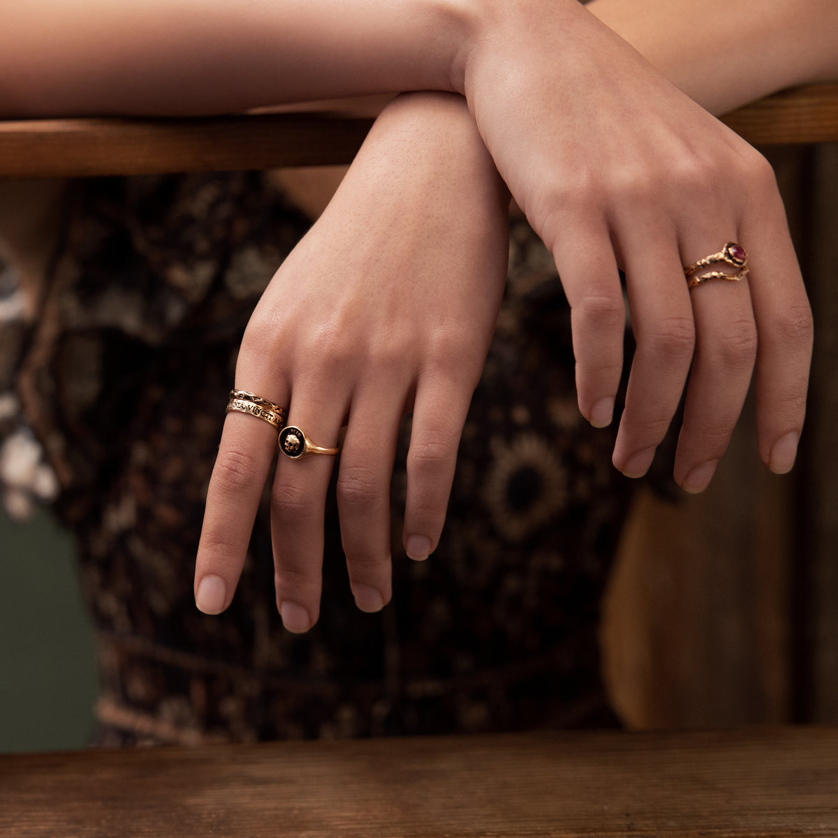 A close up of two hands wearing our Omnia Vincit Amor 14K Gold Latin Motto Band Ring.