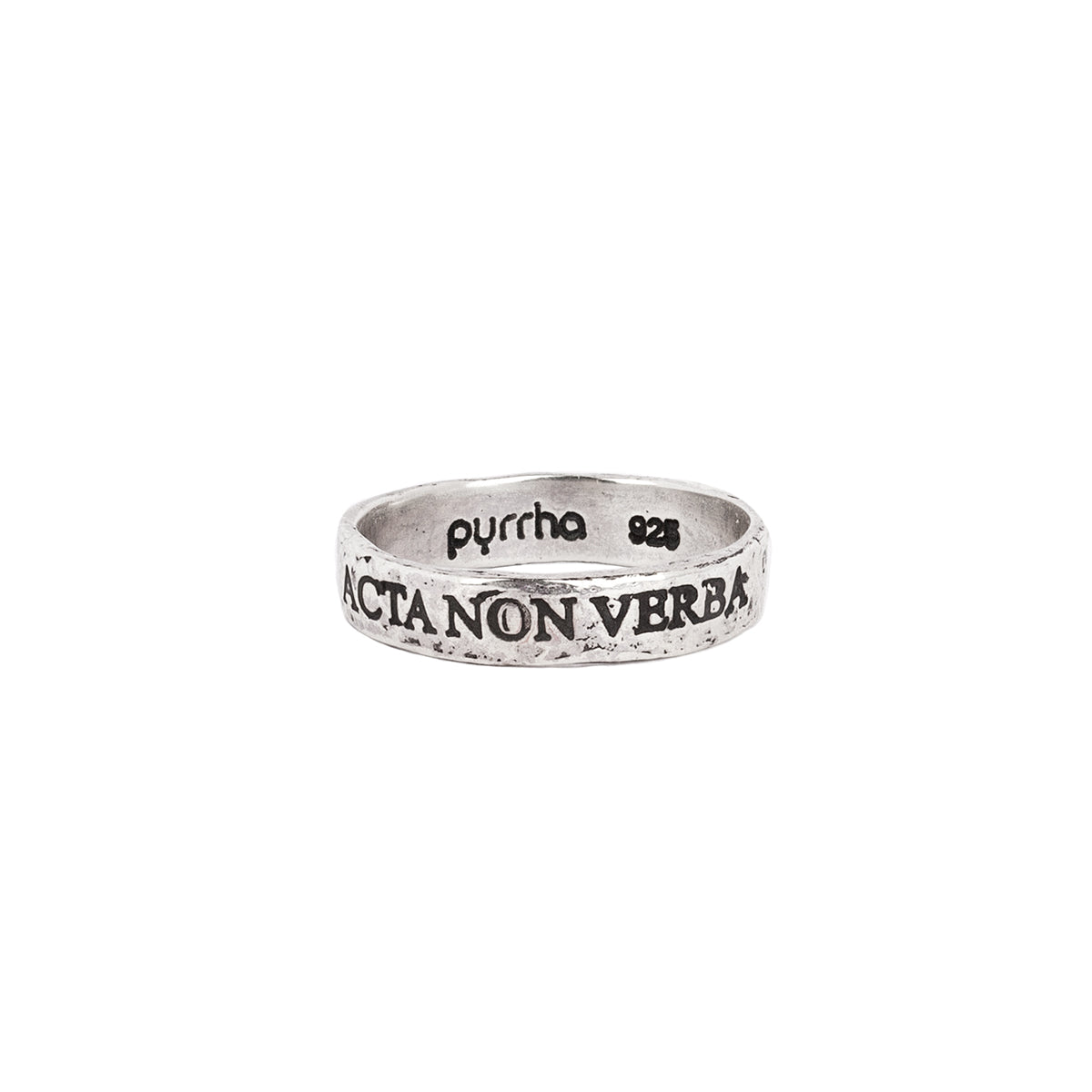 A silver band ring with the phrase Acta Non Verba engraved into it