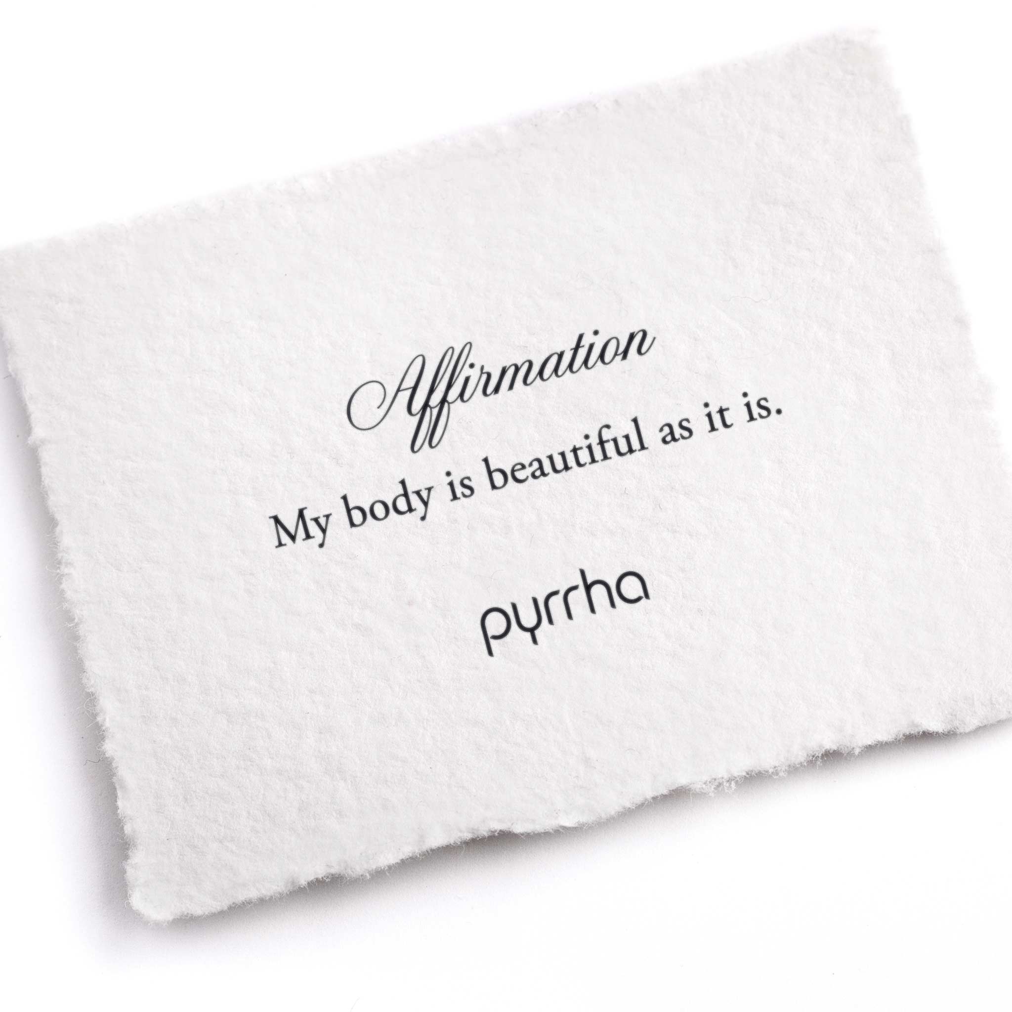 A hand-torn, letterpress printed card describing the meaning for Pyrrha's My body is beautiful as it is Affirmation Talisman