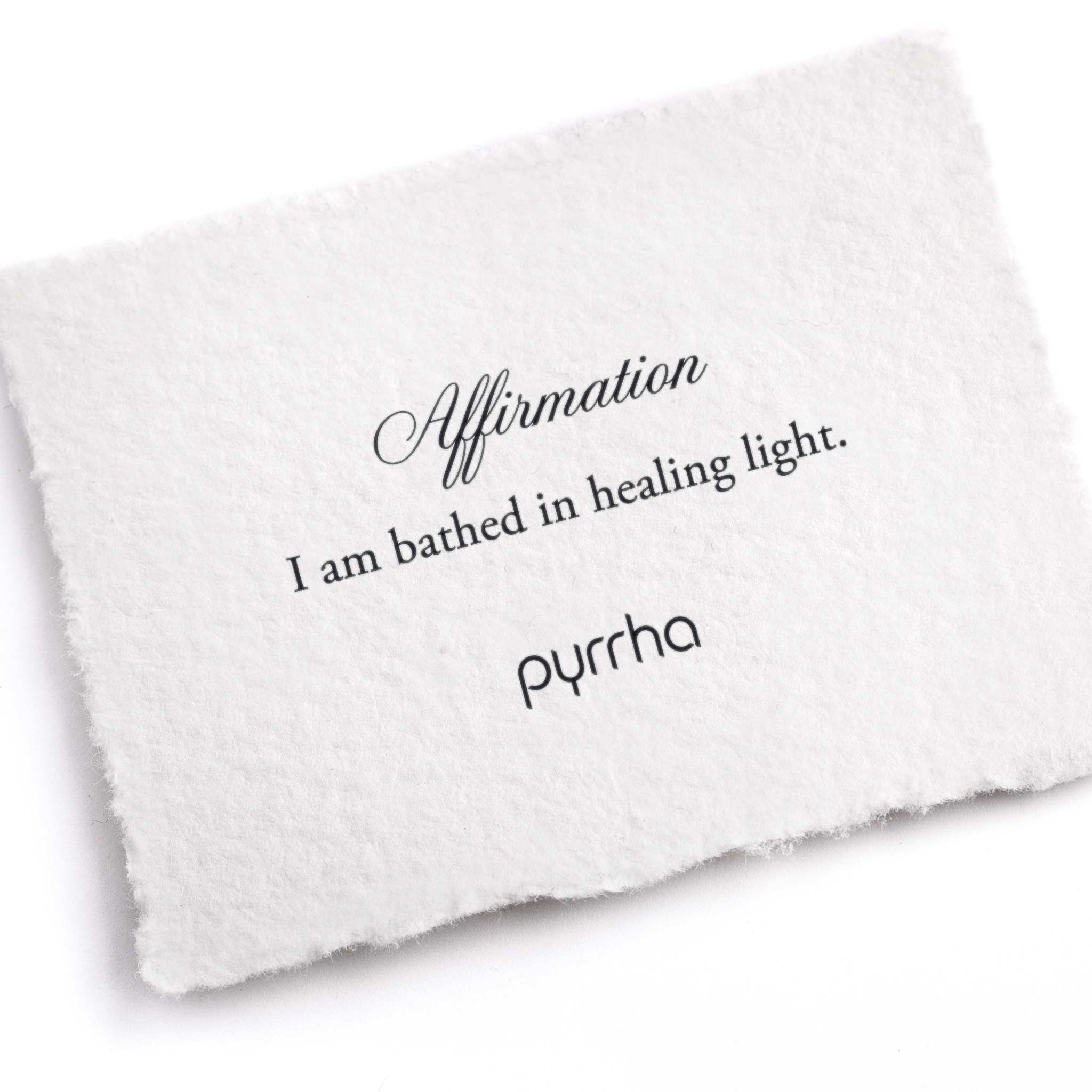 A hand-torn, letterpress printed card describing the meaning for Pyrrha's I am bathed in healing light Affirmation Talisman