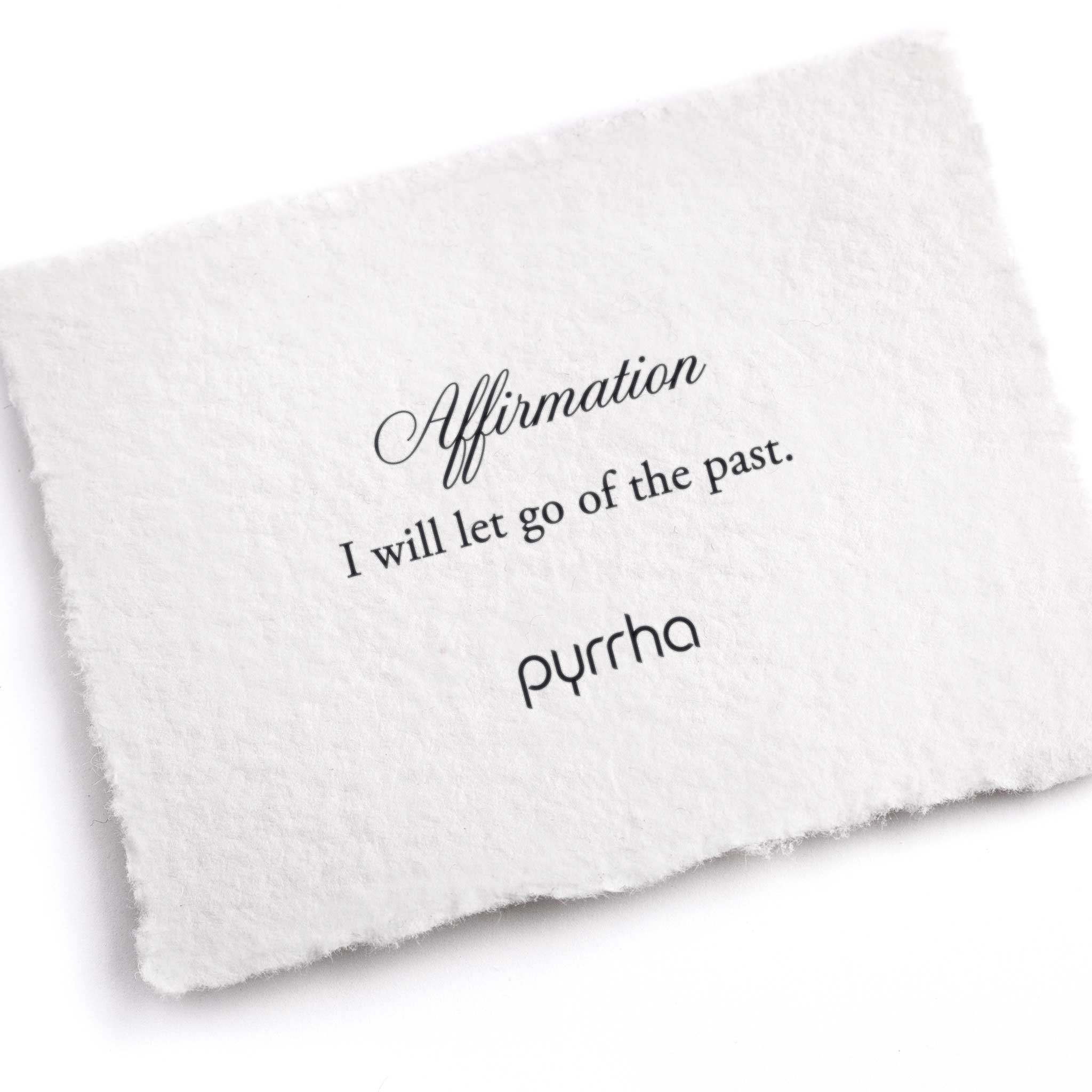 A hand-torn, letterpress printed card describing the meaning for Pyrrha's I will let go of the past Affirmation Talisman