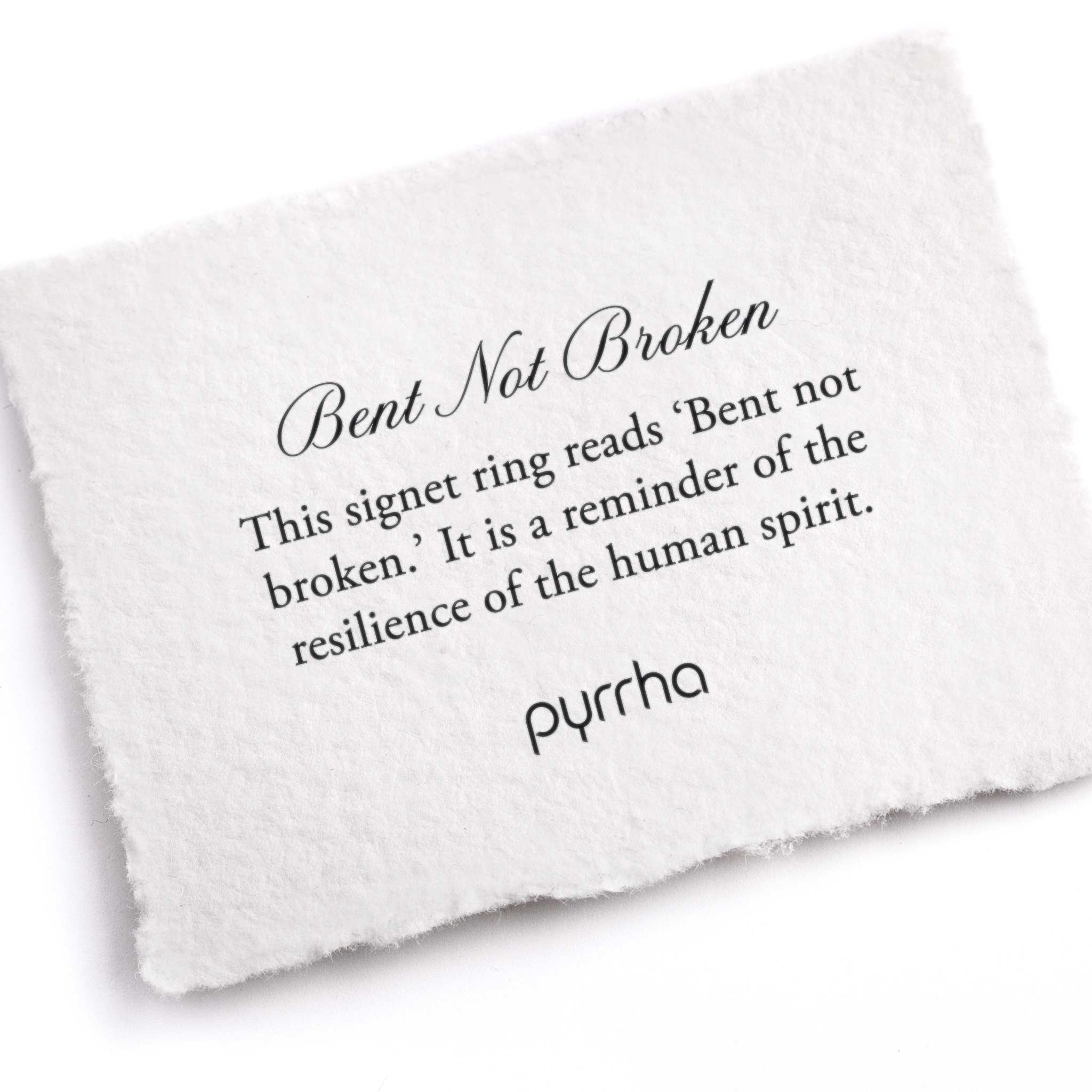 A hand-torn, letterpress printed card describing the meaning for Pyrrha's Bent Not Broken Signet Ring