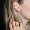 A close up of a model wearing our Large Diamond Set 14K Gold Studs.