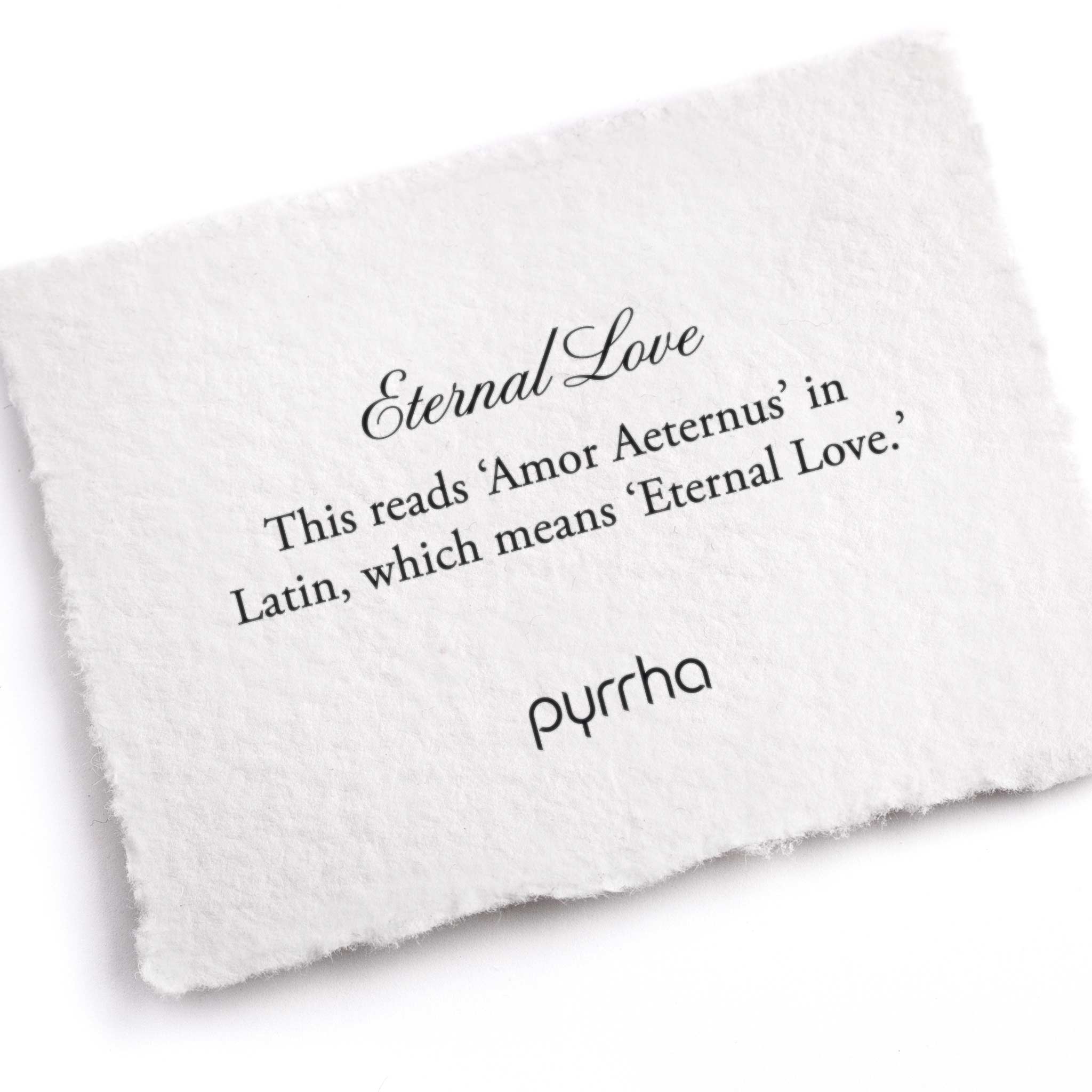 A hand-torn, letterpress printed card describing the meaning for Pyrrha's Eternal Love Latin Textured Band Ring