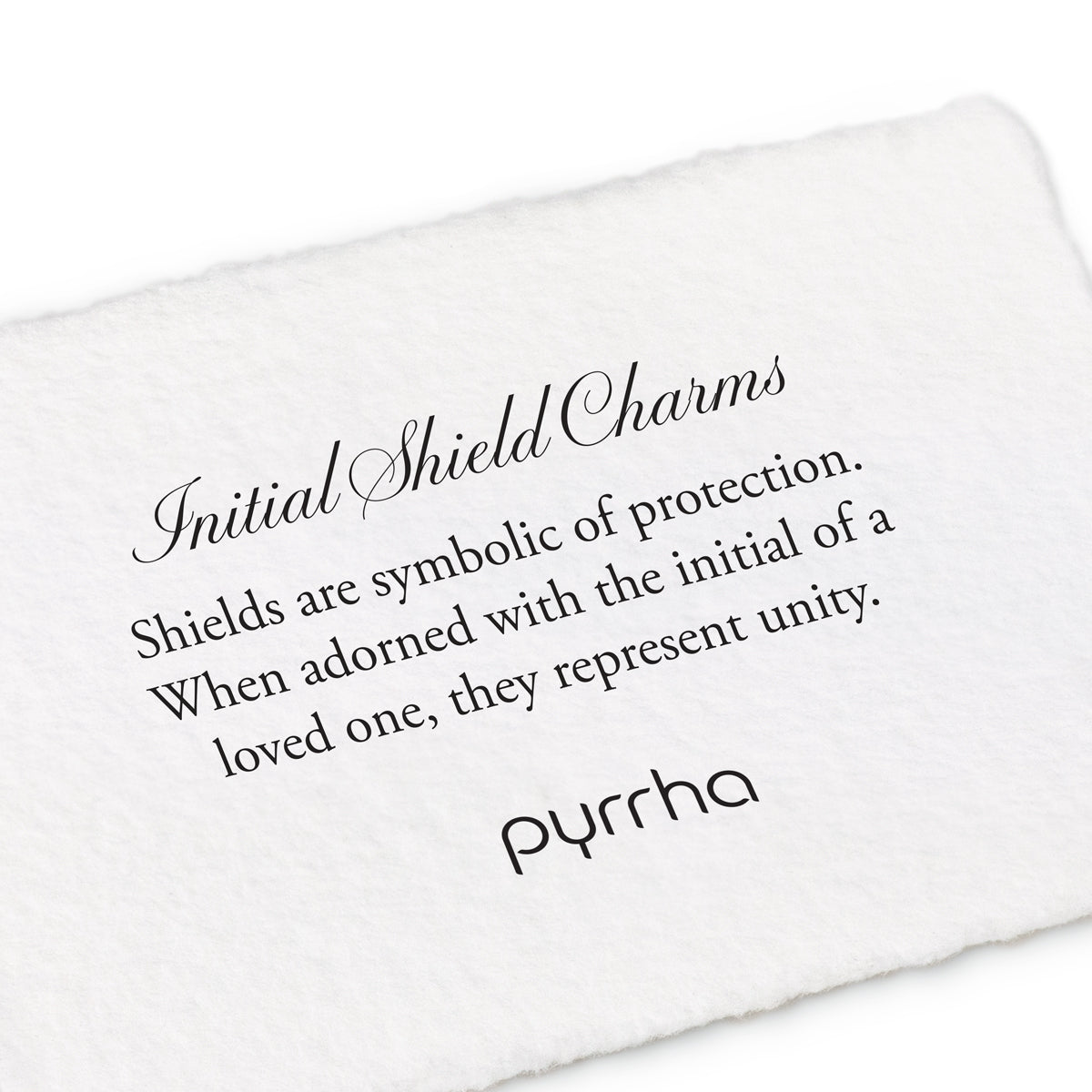 A hand-torn, letterpress printed card describing the meaning for Pyrrha's Initial Shield Charms