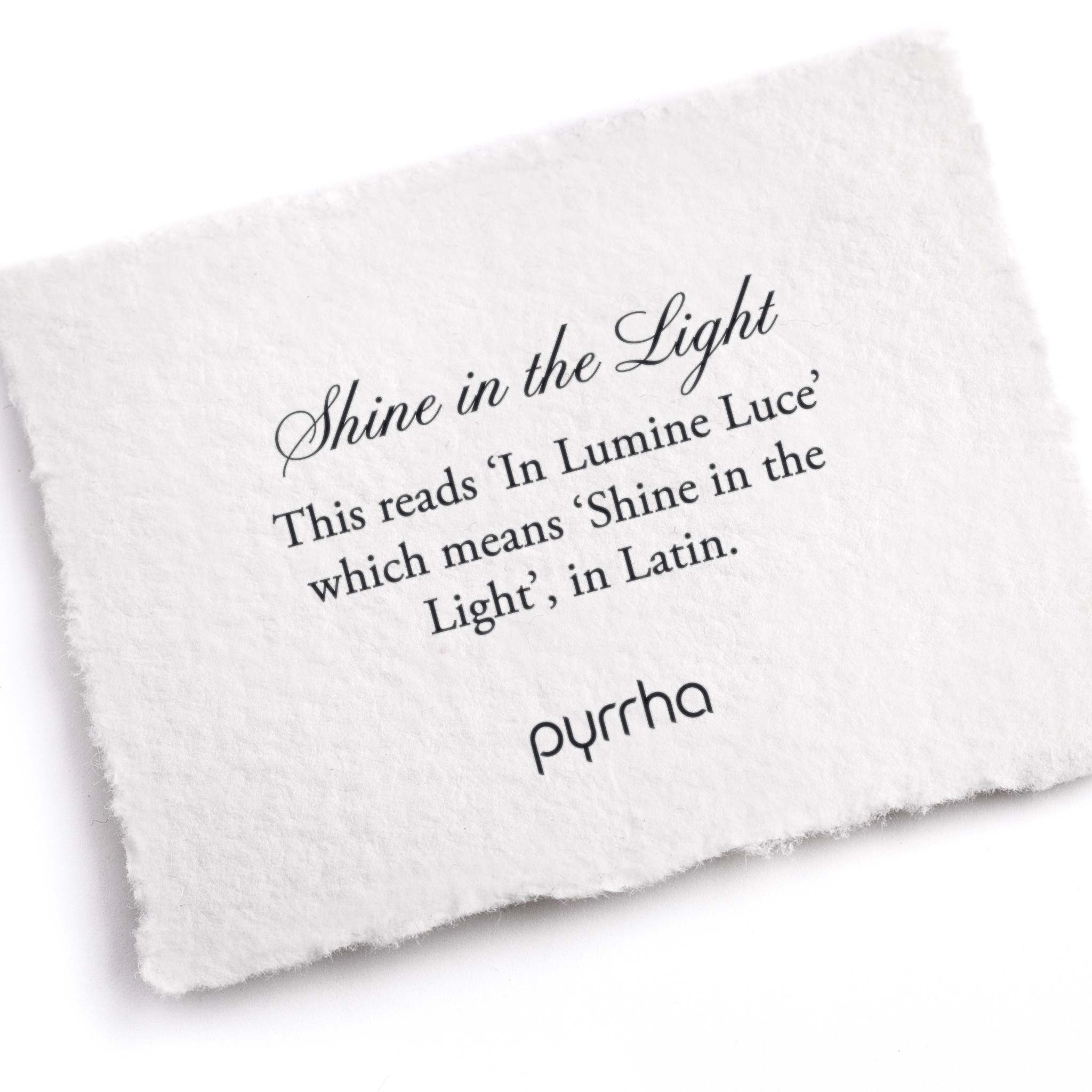 A hand-torn, letterpress printed card describing the meaning for Pyrrha's Shine In The Light Ring