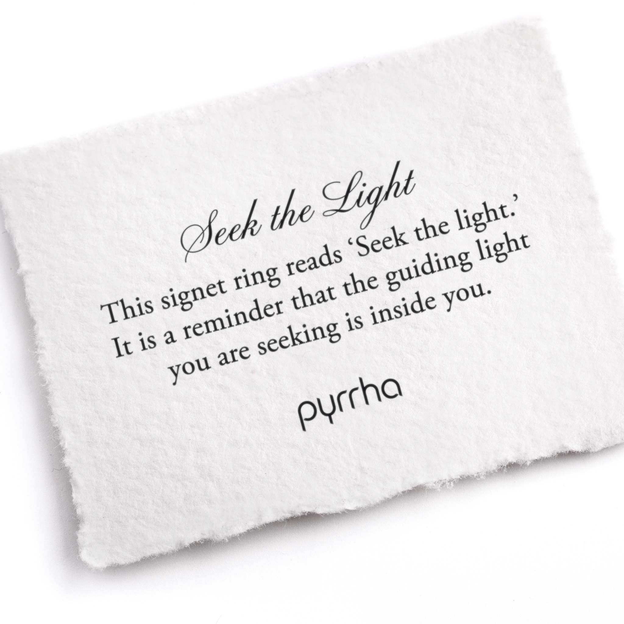 A hand-torn, letterpress printed card describing the meaning for Pyrrha's Seek the Light Signet Ring