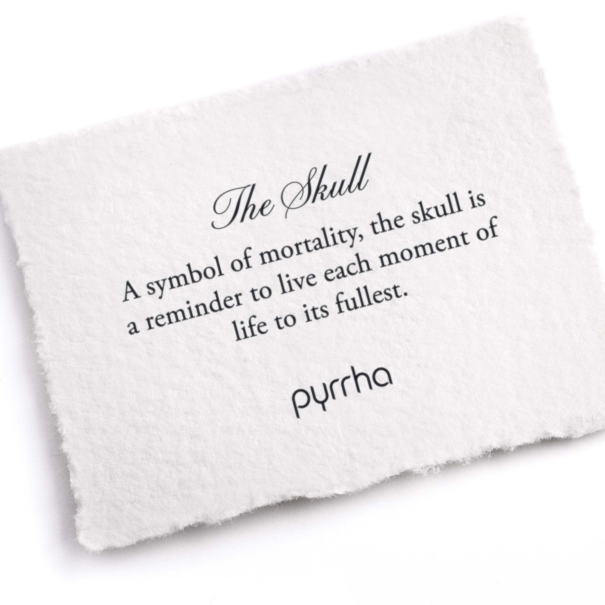A hand-torn, letterpress printed card describing the meaning for Pyrrha's Skull Pin
