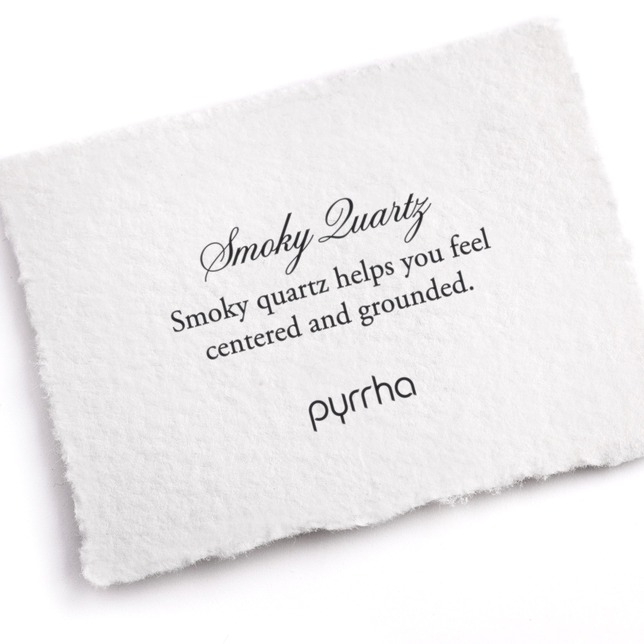 A hand-torn, letterpress printed card describing the meaning for Pyrrha's Smoky Quartz stone