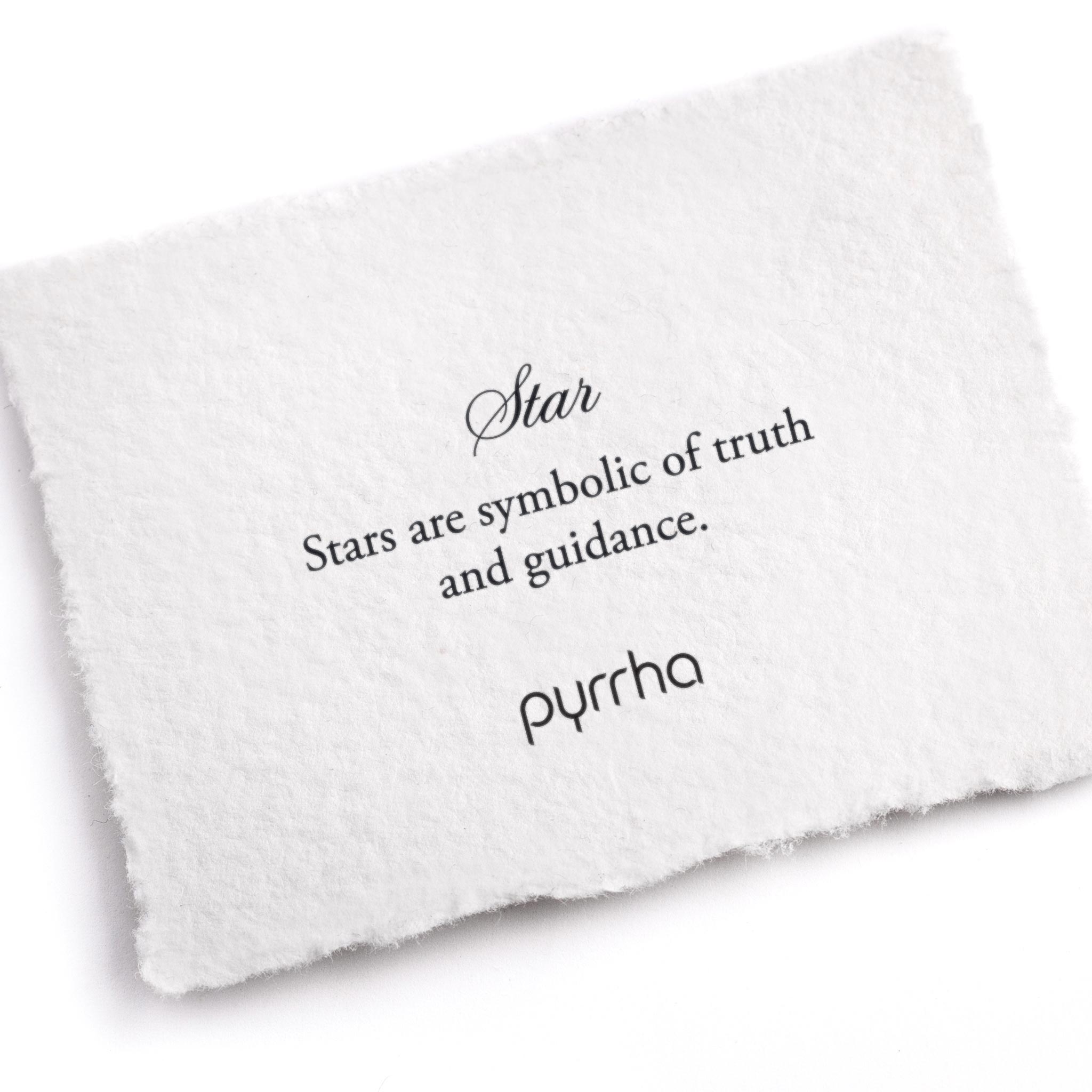 A hand-torn, letterpress printed card describing the meaning for Pyrrha's Star Symbol Charm