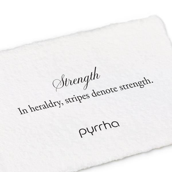 A hand-torn, letterpress printed card describing the meaning for Pyrrha's Strength Color Shield Charm