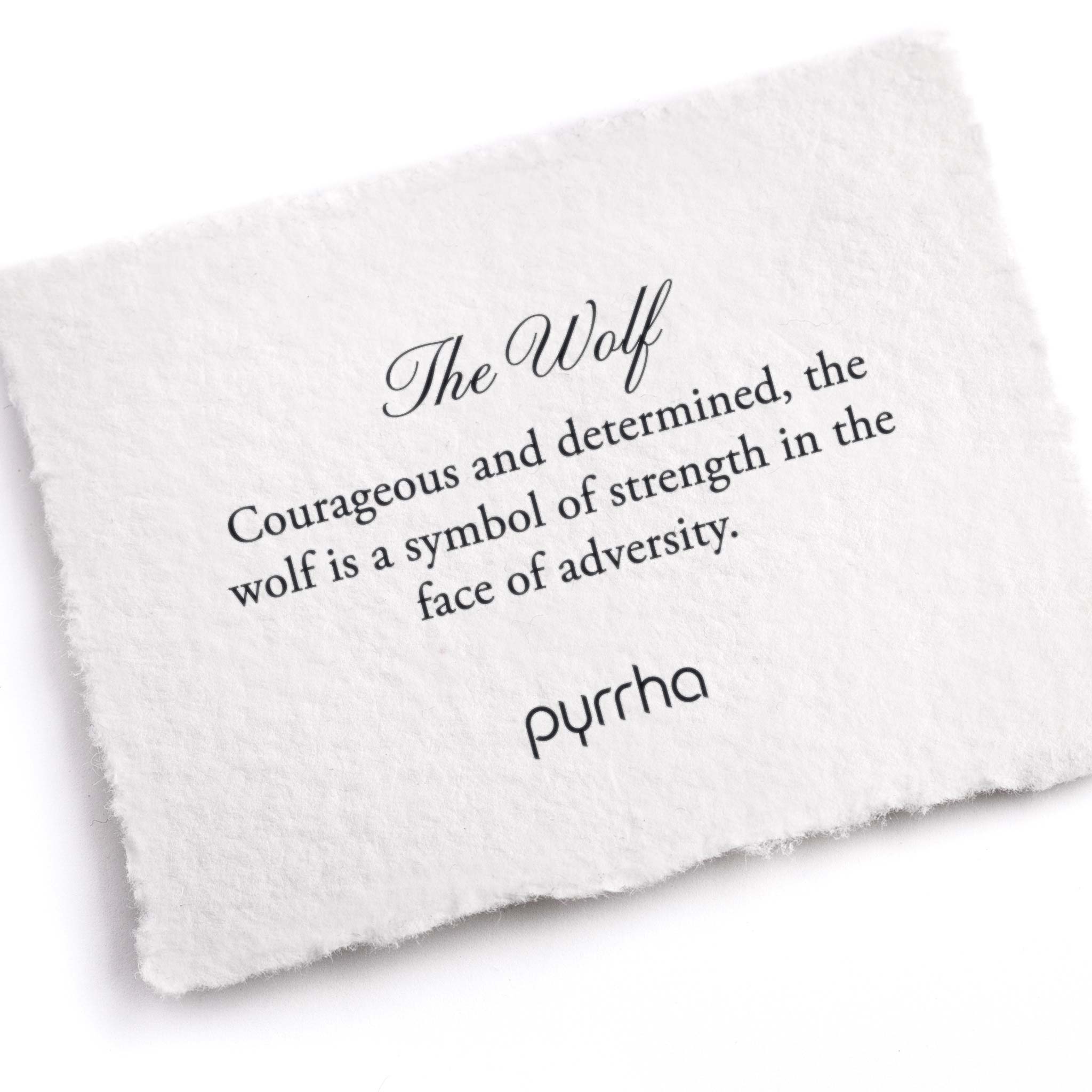 A hand-torn, letterpress printed card describing the meaning for Pyrrha's Wolf Pin
