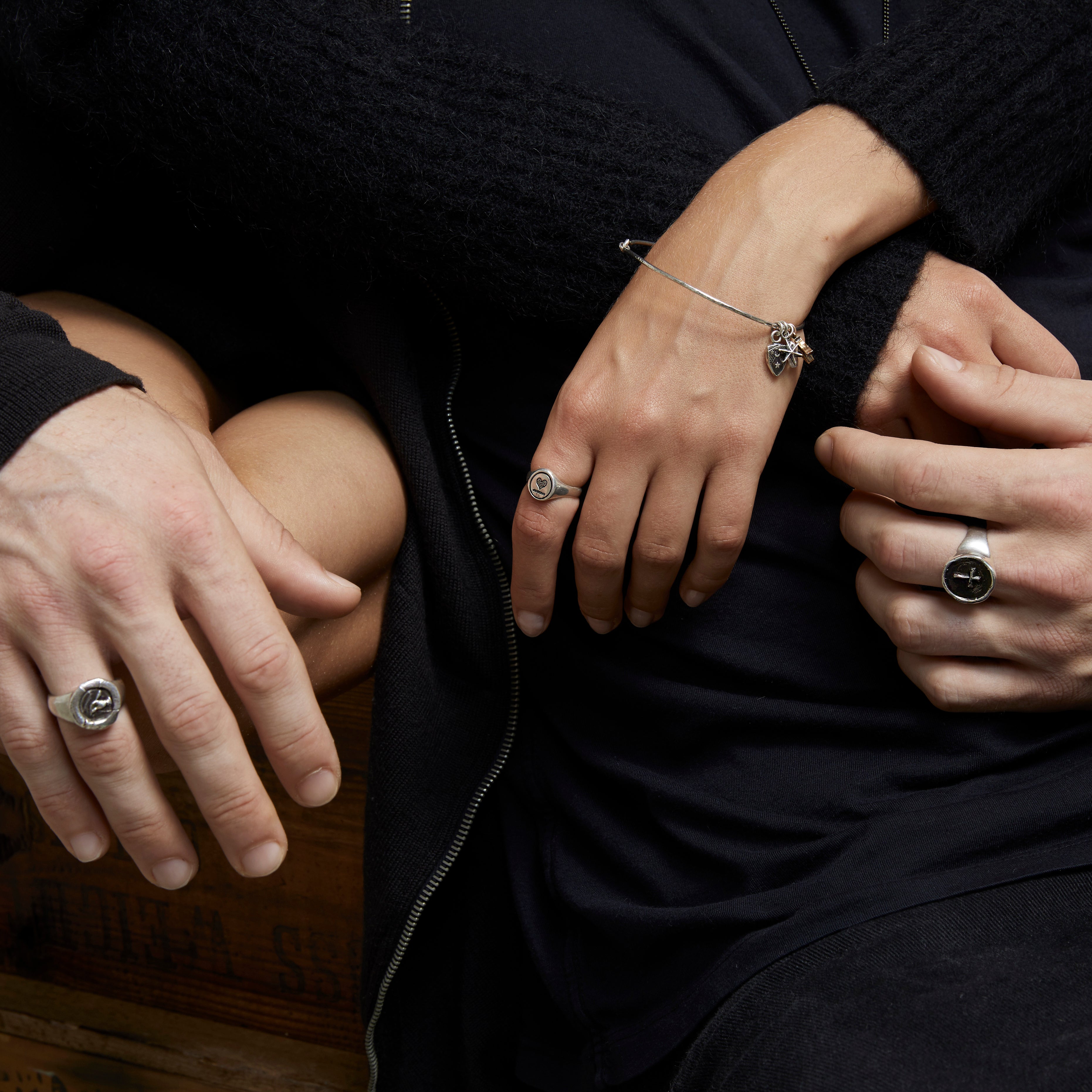 A close up of a models hands wearing our Heart Oval Signet Ring.