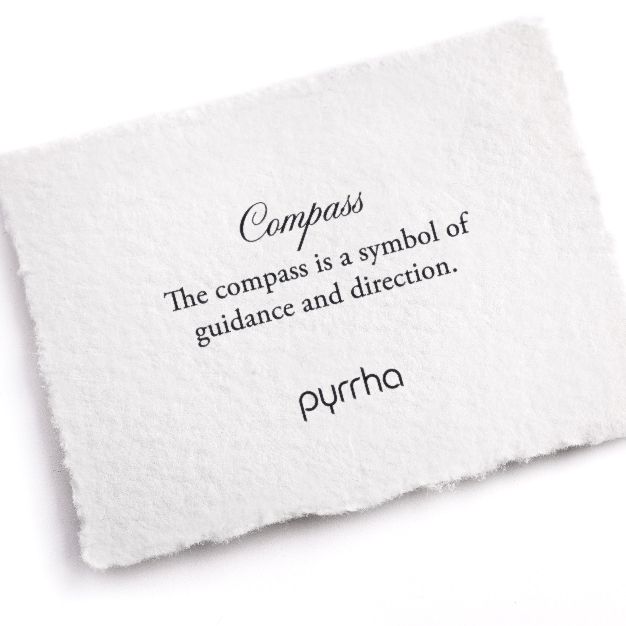 A hand-torn, letterpress printed card describing the meaning for Pyrrha's Compass Symbol Charm