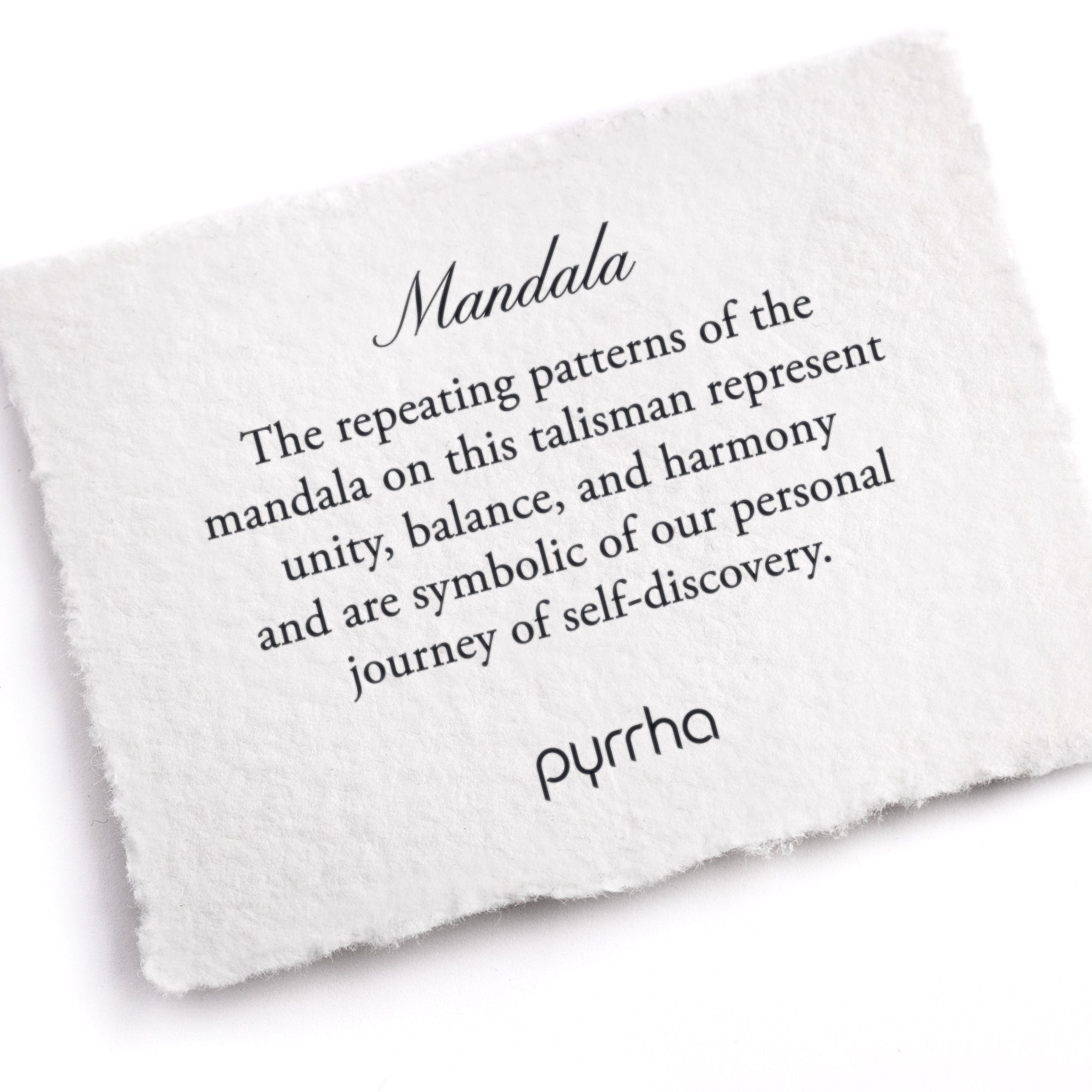 A hand-torn, letterpress printed card describing the meaning for Pyrrha's Mandala Talisman