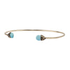 A 14k gold bangle made to hold charms capped with a semi precious stone representing Friendship.
