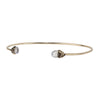 A 14k gold bangle made to hold charms capped with a semi precious stone representing improvement.