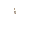 A 14k gold charm in the shape of the letter "R".