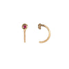 A set of 14k gold hug earrings set with a ruby.