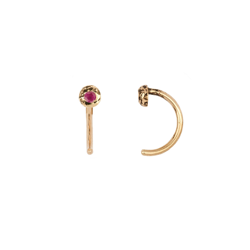 A set of 14k gold hug earrings set with a sapphire.