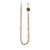 A necklace of hand strung champagne pearls with a 14k gold bezel set charcoal diamond.