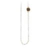 A necklace of hand strung white ivory pearls with a 14k gold bezel set charcoal diamond.