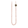 A necklace of hand strung rose pearls with a 14k gold bezel set charcoal diamond.