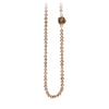 A necklace of hand strung champagne pearls with a 14k gold bezel set cognac diamond.