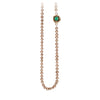 A necklace of hand strung champagne pearls with a 14k gold bezel set emerald.