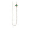 A necklace of hand strung ivory white pearls with a 14k gold bezel set emerald.