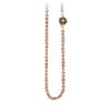 A necklace of hand strung champagne pearls with a 14k gold bezel set grey diamond.
