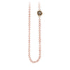 A necklace of hand strung rose pearls with a 14k gold bezel set grey diamond.