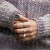 A close up of a models hand wearing our Heart Lock Symbol Charm Ring.