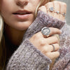 A close up of a model wearing a selection of Pyrrha rings including our Heart Symbol Charm Ring.