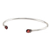 An open silver bangle capped with semi precious stones promoting clarity