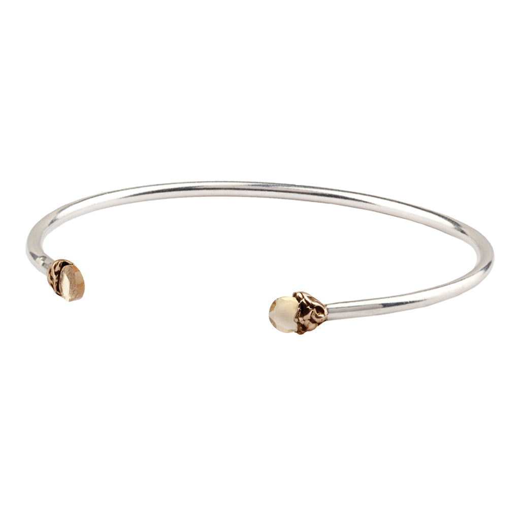 An open silver bangle capped with semi precious stones promoting confidence