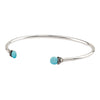An open silver bangle capped with semi precious stones promoting friendship