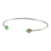 An open silver bangle capped with semi precious stones promoting healing