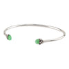 An open silver bangle capped with semi precious stones promoting healing