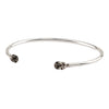 An open silver bangle capped with semi precious stones promoting prosperity