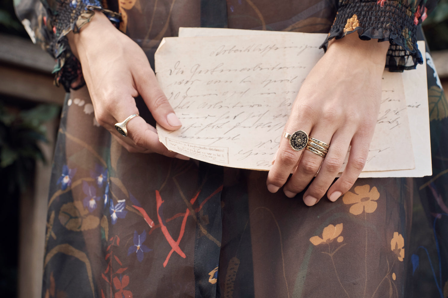 A close up of a model wearing our Courage To Challenge Life 14K Gold Poesy Ring on her hand.