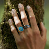 A close up of a models hand wearing our Ab Hinc 14k Gold Narrow Texture Band Ring - Mediterranean Blue