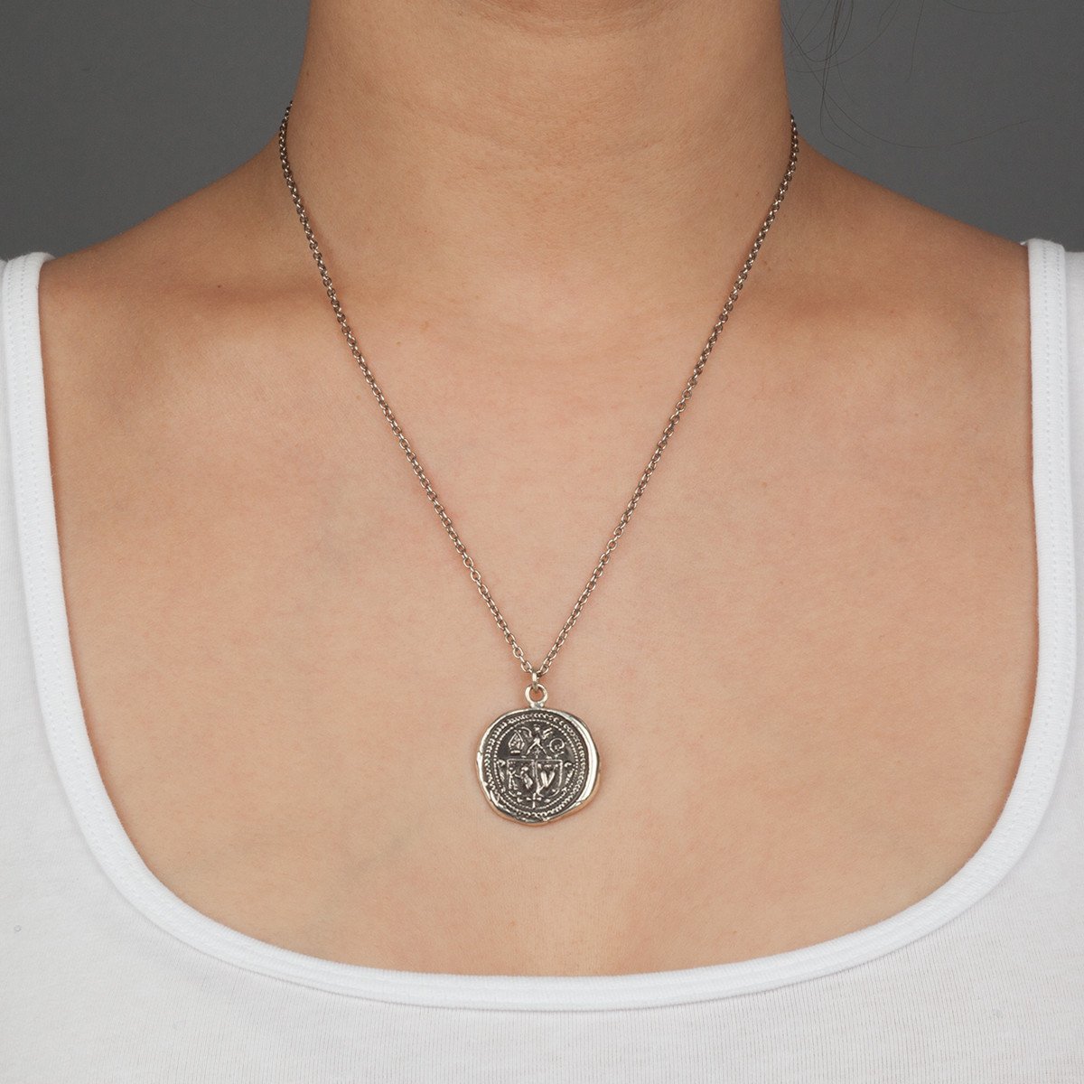 A close up of a model wearing Pyrrha's sterling silver Nuturing Talisman Necklace.